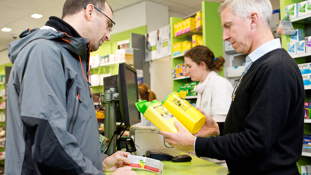 Un pharmacien d&eacute;livre des bo&icirc;tes &agrave; un patient pour la r&eacute;cup&eacute;ration de ses d&eacute;chets de soin