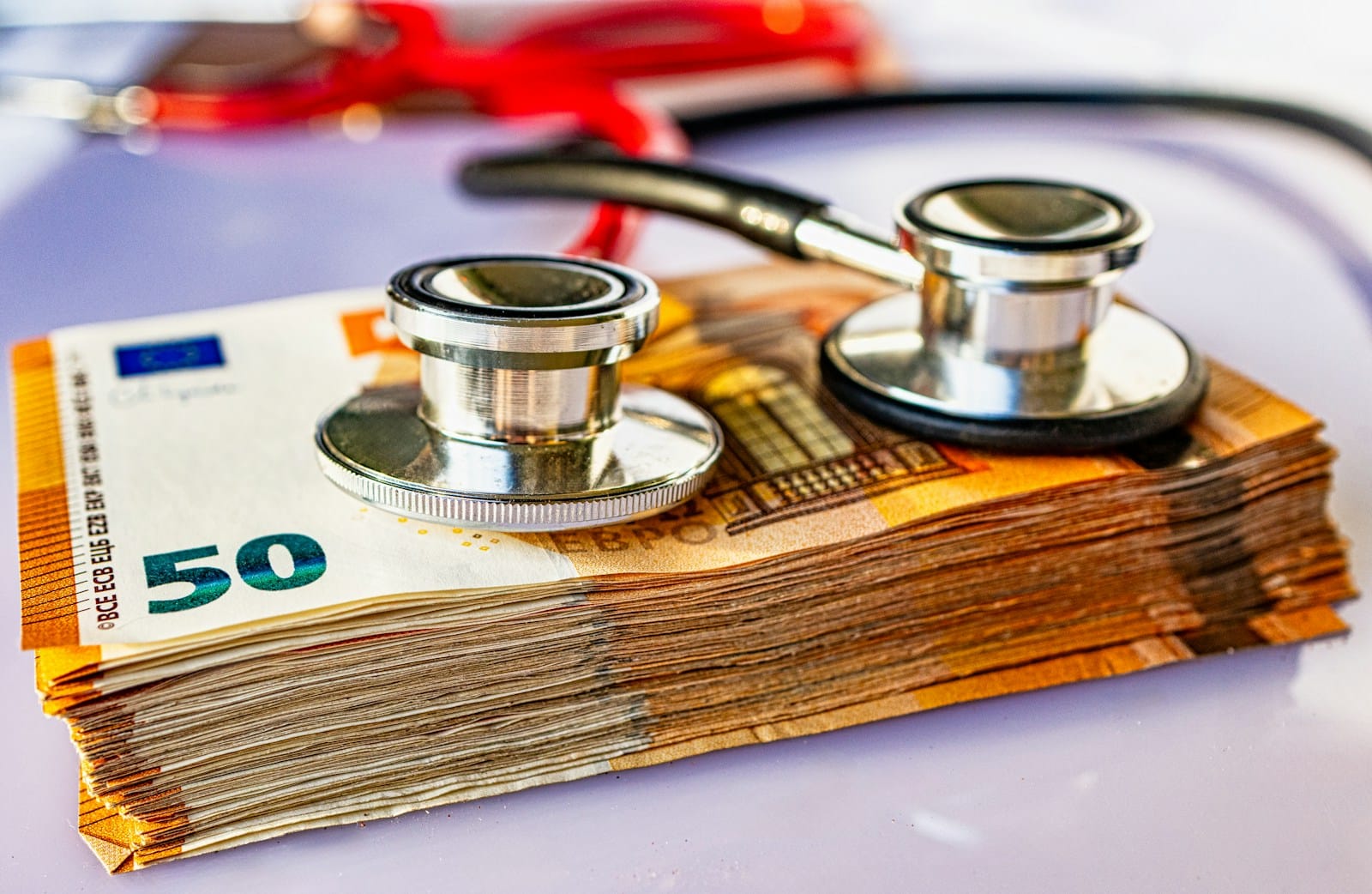 a pile of money with a stethoscope on top of it